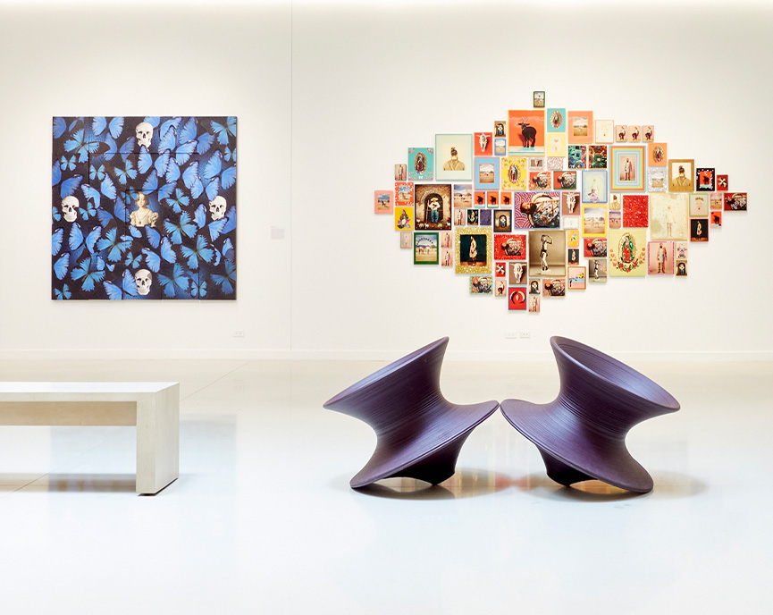 collage on wall next to blue butterflies with 2 tipsy chairs