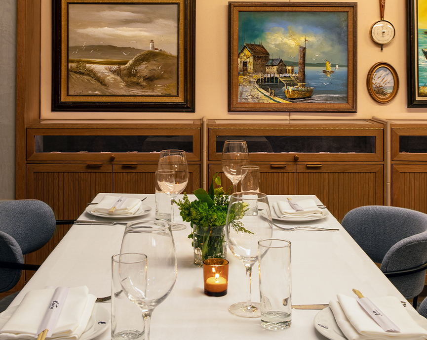 small table with blue chairs and sea pictures on the wall