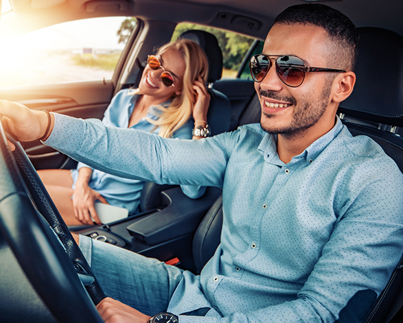 man and woman with sunglasses on in the car