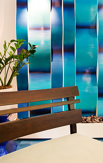 blue ocean colored wall behind a wooden bench