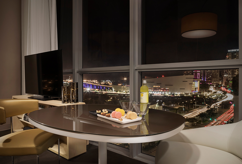 a table with the view of downtown miami during the night time in the background