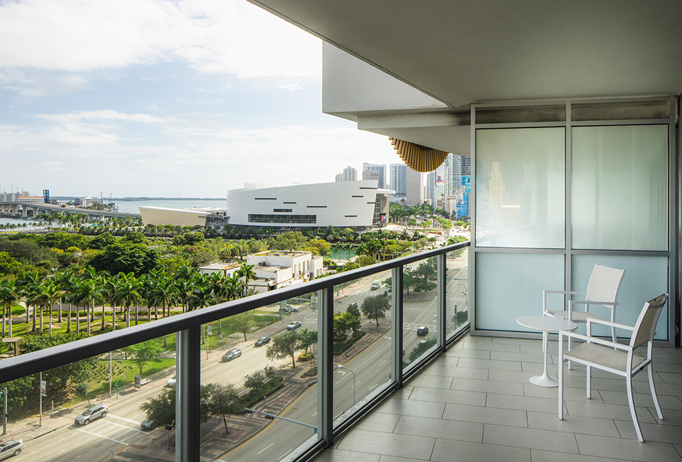 view from a hotel balcony with a table and two chairs and city view in background