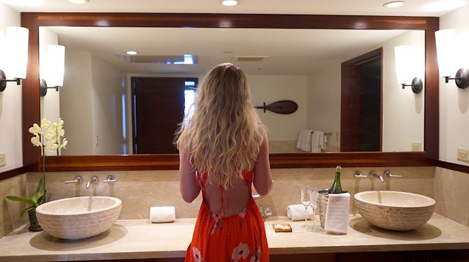 woman looking at her self in the bathroom