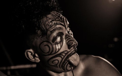 zoomed view of man's face with tribal tattoos on his face