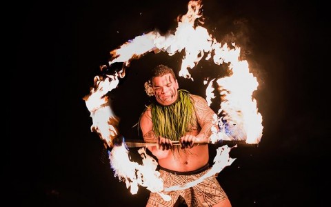 man dancing with fire for a luau