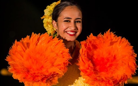 woman holding orange fans made of feathers