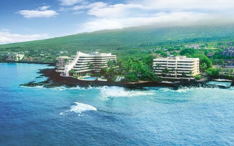 aerial view of royal kona resort at hawaii with the ocean up front and mountains in the back