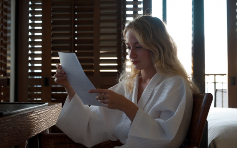 women sitting in robe reviewing printed document