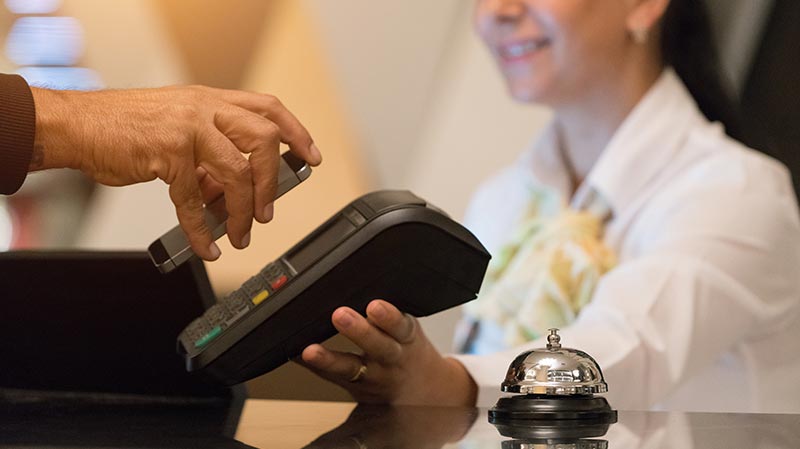 person paying with iphone on the reception