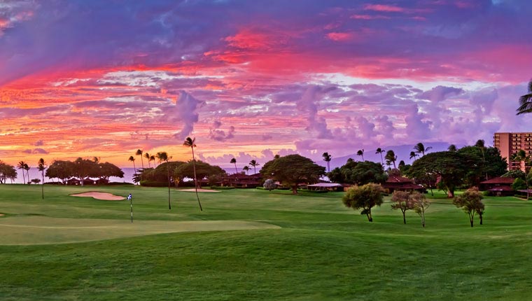 view of property golf course at sunset