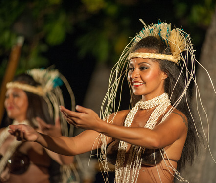 women wearing coconut bra and Hawaiian headdress dancing in luau 