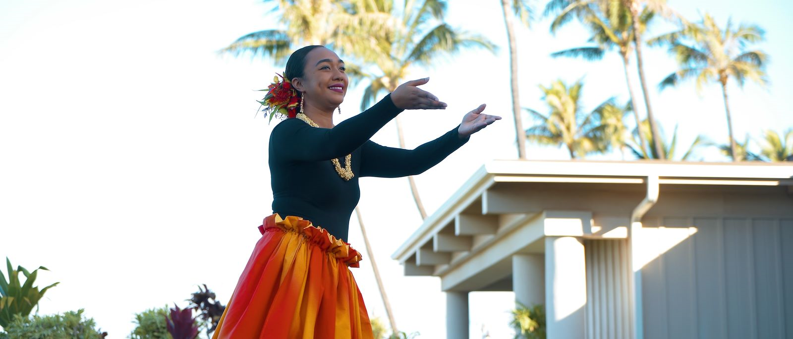 woman with orange skirt performing hula