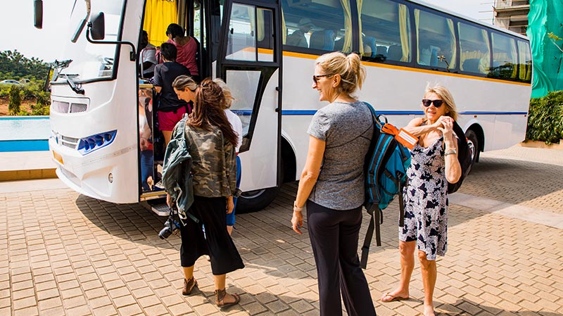 women making a line to hop on a bus