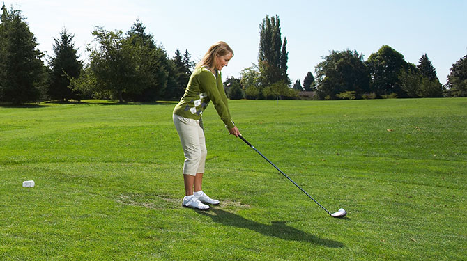 woman in position to take a golf shot