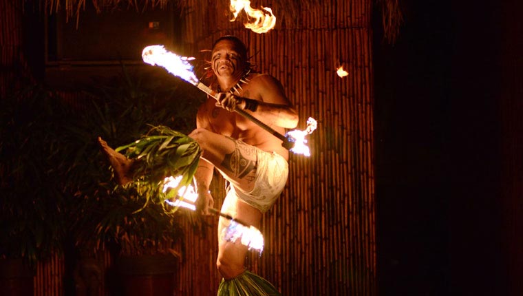 a man performing a fire dance at a luau