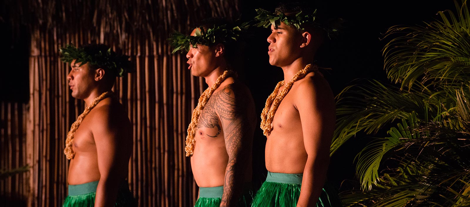 two shirtless men performing at a luau