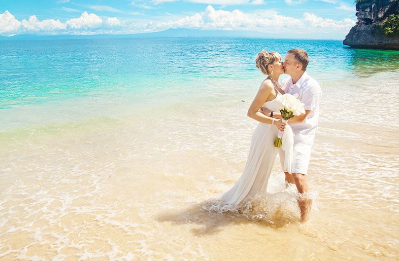 couple kissing all dressed up on the beach