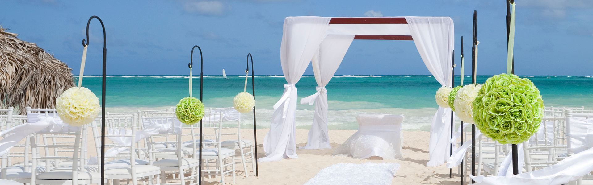 bright wedding venue altar with white curtains right on the ocean sand