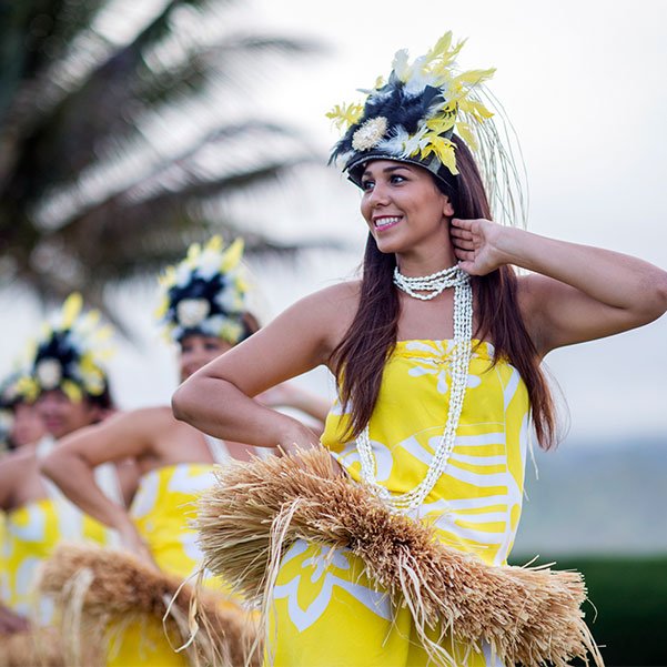 women performing luau in bright yelllow dresses