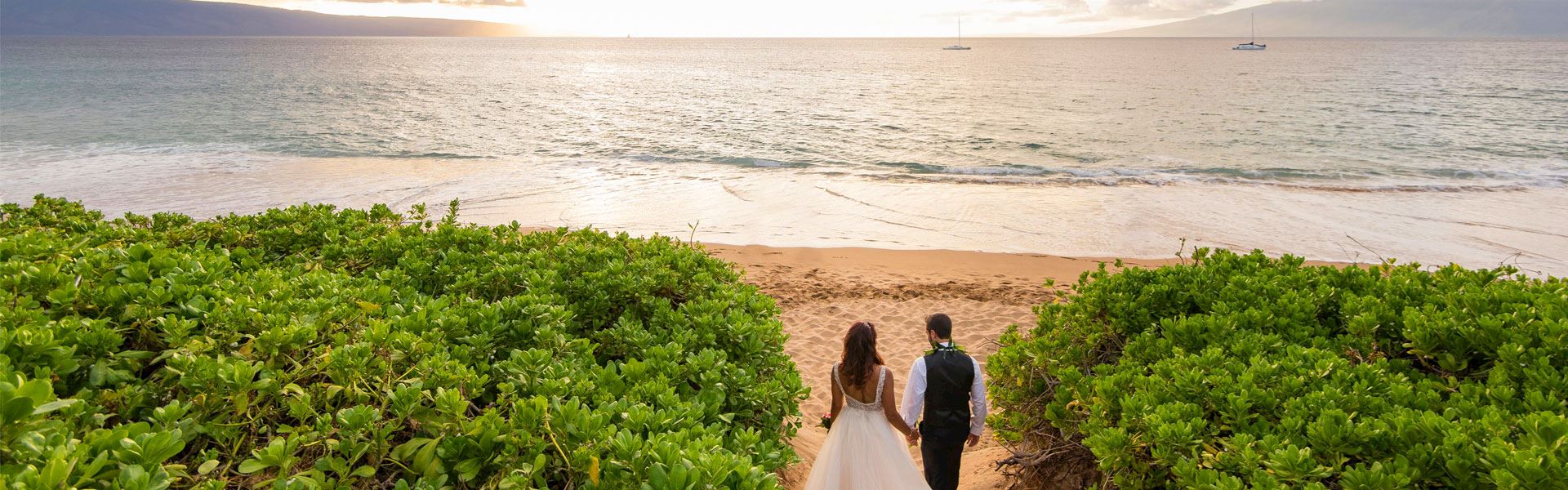 a couple walking on the sand after their wedding