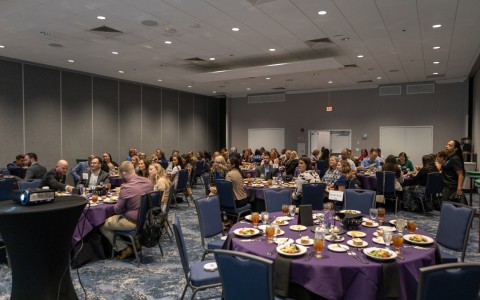 room full of people at purple tables