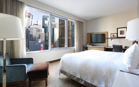 business king room with the bed facing a window and view of the city.