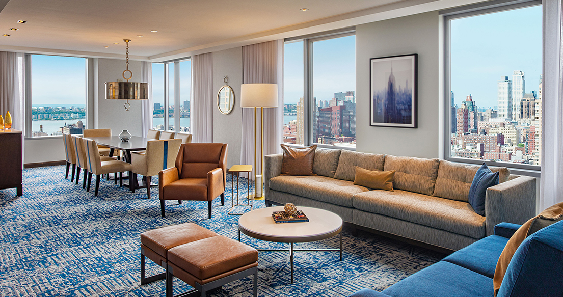 couches on a blue carpet in a room overlooking the city