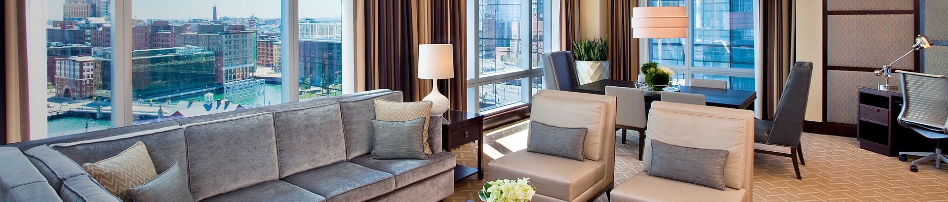 large room with couches, armchairs, and a view of the city