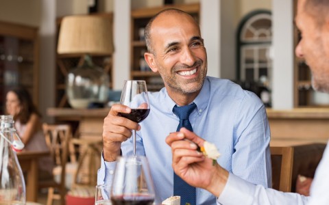 two men enjoying dinner and wine