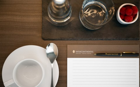 Overhead shot of desk with coffee cup and notepad