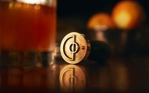 company pin with cocktail in background