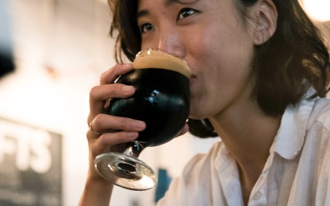 person drinking a dark beer