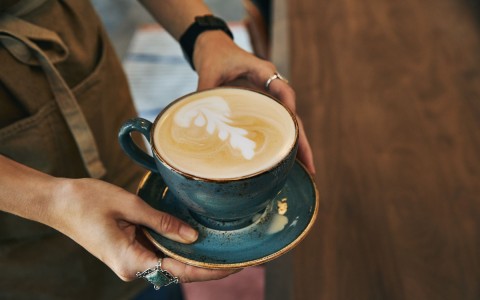 womans hand holding coffee cup