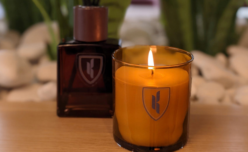 custom candle with the kinley logo shield on the glass