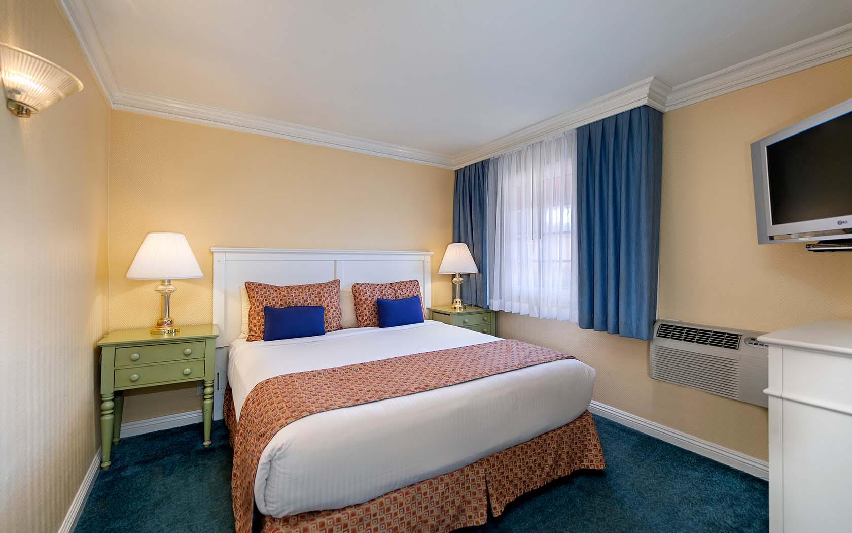 Comfy hotel bedroom designed in warm beige tones  and tailored to the needs of private and business travelers alike
