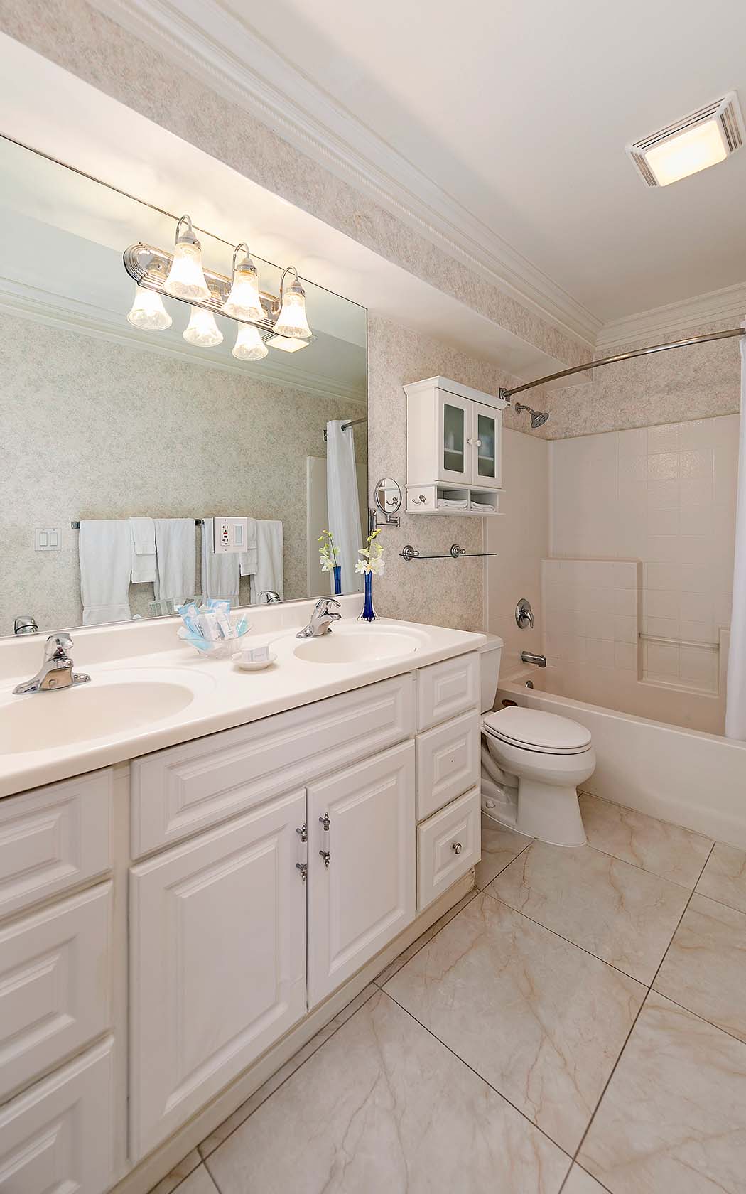 corner view of a spacious private bathroom in white accents 