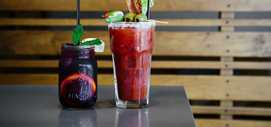 tall glass with a bloody mary cocktail and garnishes