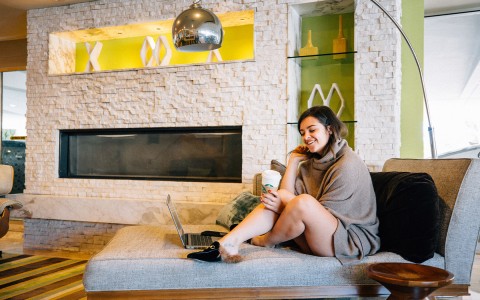 woman lounging on a couch enjoying her coffee