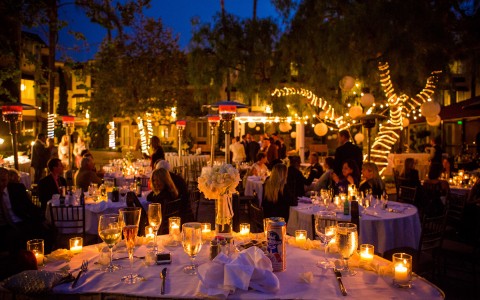 Tables with twinkling lights at an outside wedding