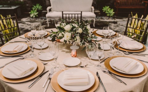 table filled with plates and centerpiece for a wedding