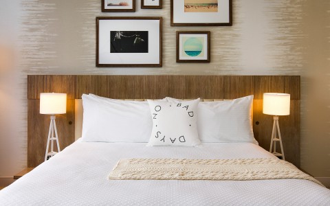 view of comfortable fluffy bed with a collage of frames as a headboard