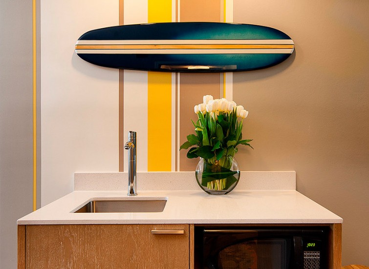 hotel room sink, microwave and decorative surfboard