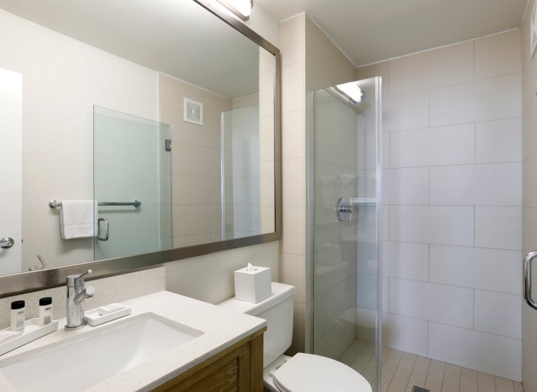 hotel bathroom with vanity and glass shower