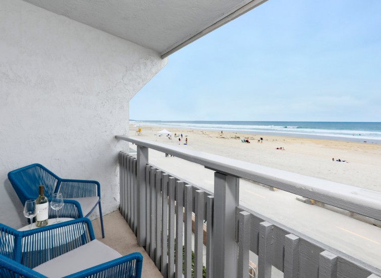 Balcony with 2 blue chairs facing the ocean