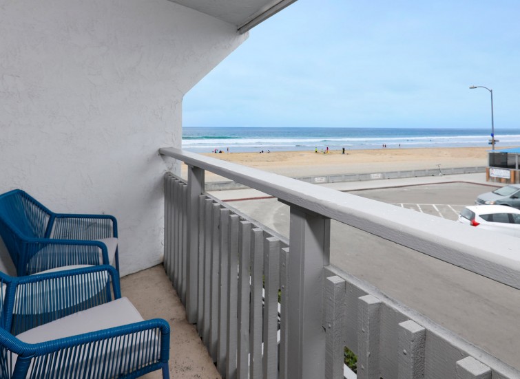 Balcony with 2 blue chairs facing the ocean