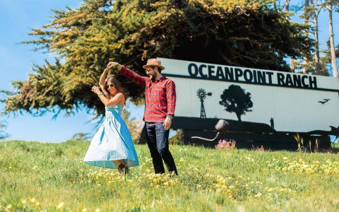 A couple dancing next to a big oceanpoint ranch billboard 