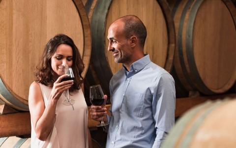 A man and a woman drinking wine on a winery
