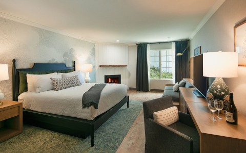 Internal view of a Guest Room with a confortable bed and an electric fireplace