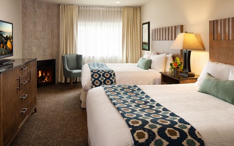 hotel room with 2 beds and a fireplace
