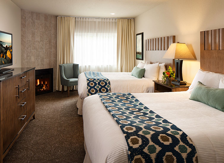 hotel room with 2 beds and a fireplace